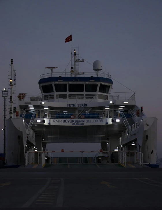 a large white ship docked at night time