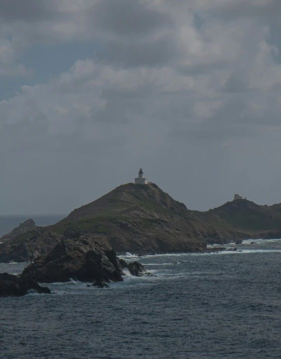 some land with a lighthouse near the water