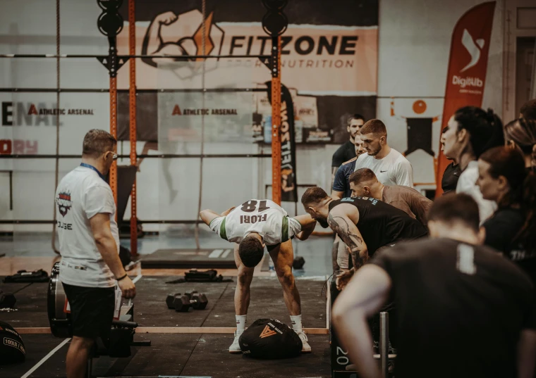 two men performing a deadlift as people watch