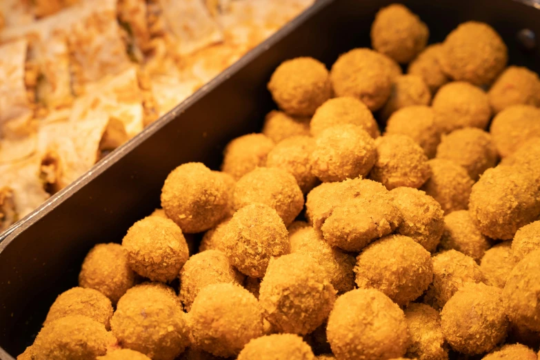 small balls of food sitting in a brown tray