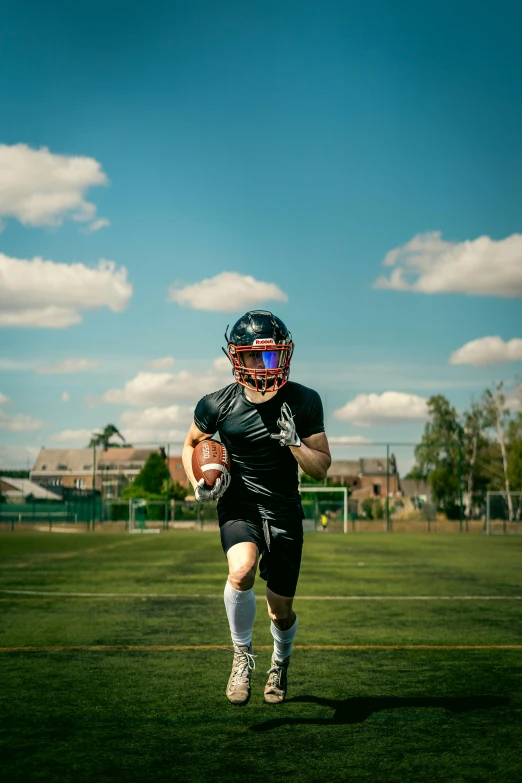 the american football player runs with his ball