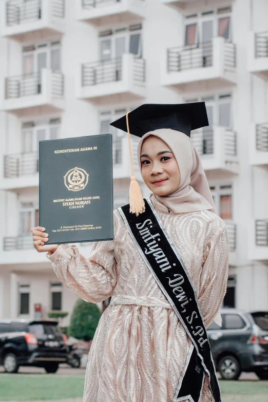 a woman with a robe holding a diploma