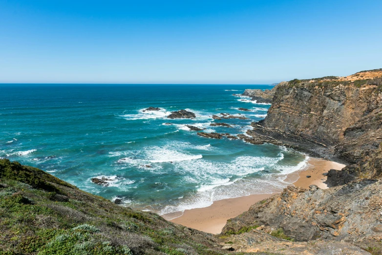 a beautiful view of the ocean near a large cliff