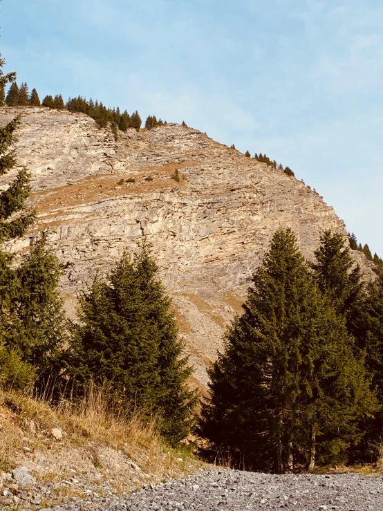 the mountain is covered in rocky terrain with trees lining its sides