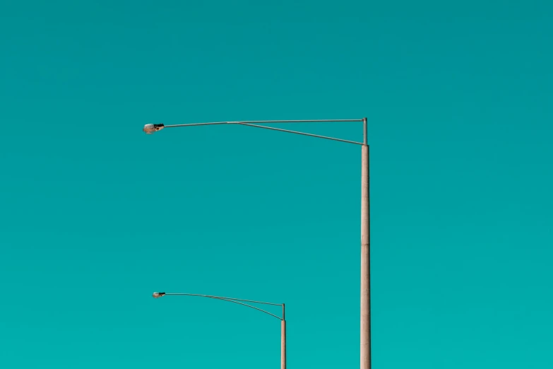 a street light on an empty street with a blue sky