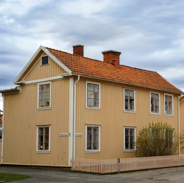 a tan building with two chimneys and no roof