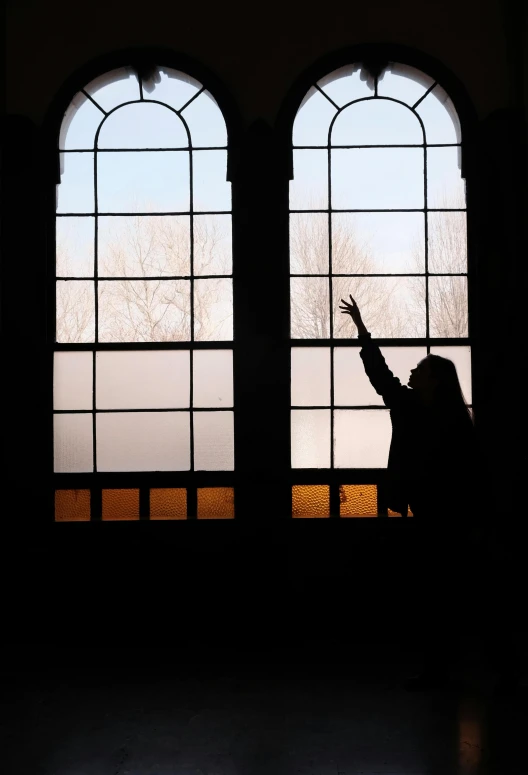 a person standing in front of two big windows