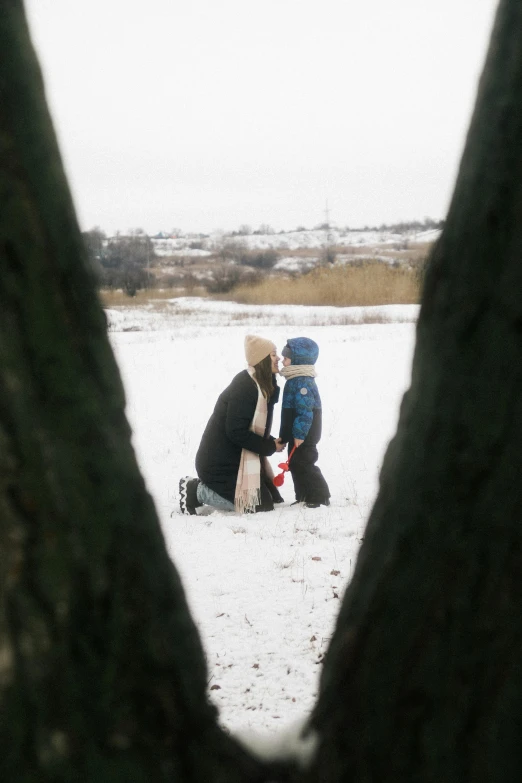 two people sitting next to each other on snow covered ground