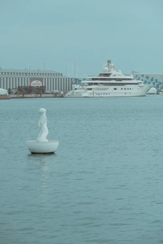 a large ship in the water next to a statue