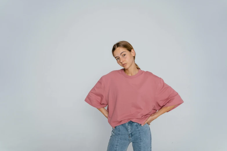 a woman standing in a white room with her hands on her hips