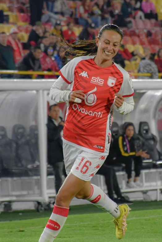 a woman wearing a soccer uniform running down the field