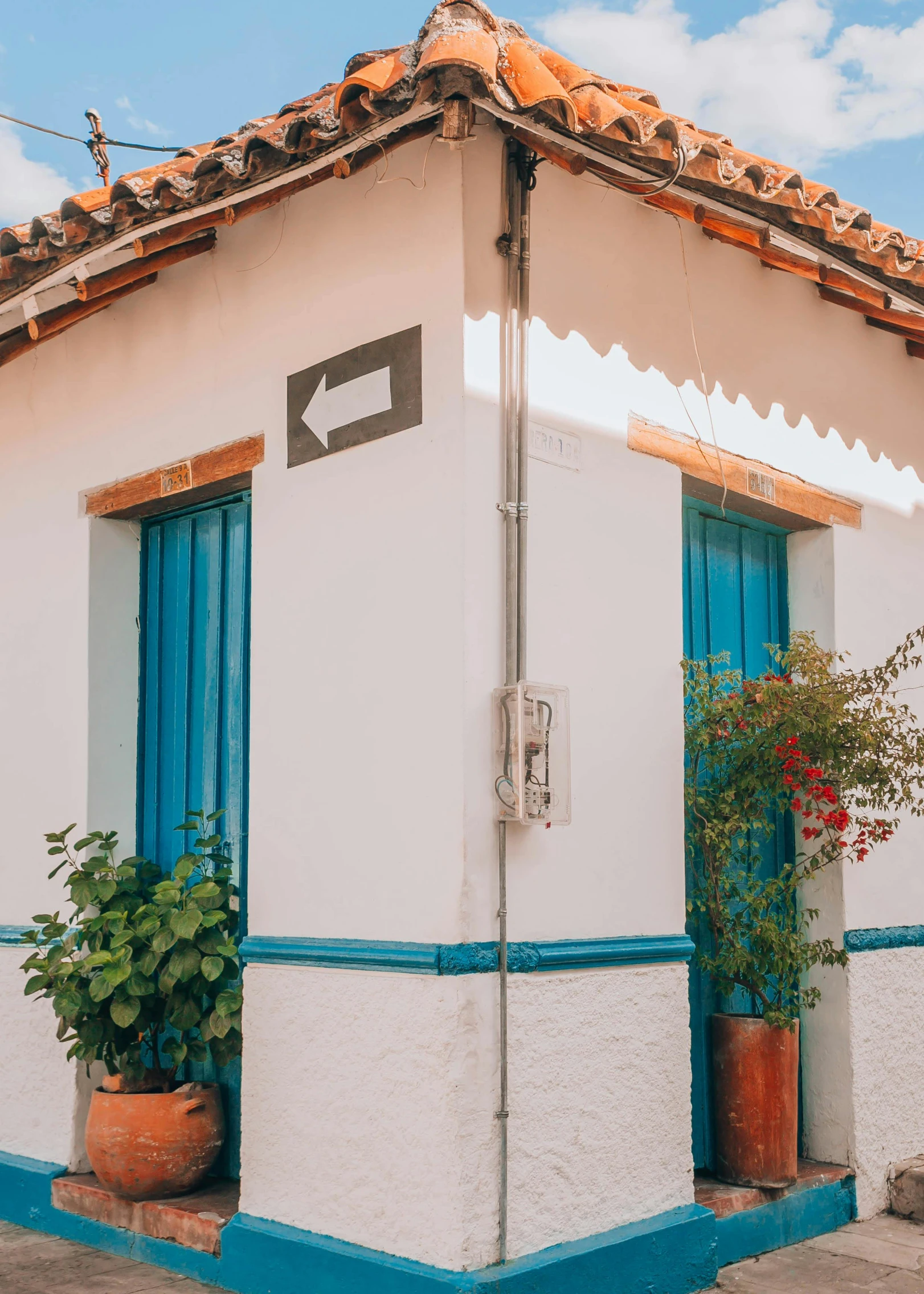 a building with a blue door has planters on the outside