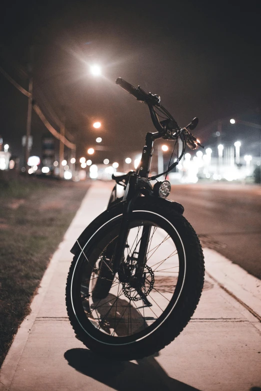 a bicycle  to a pole on the side of a street