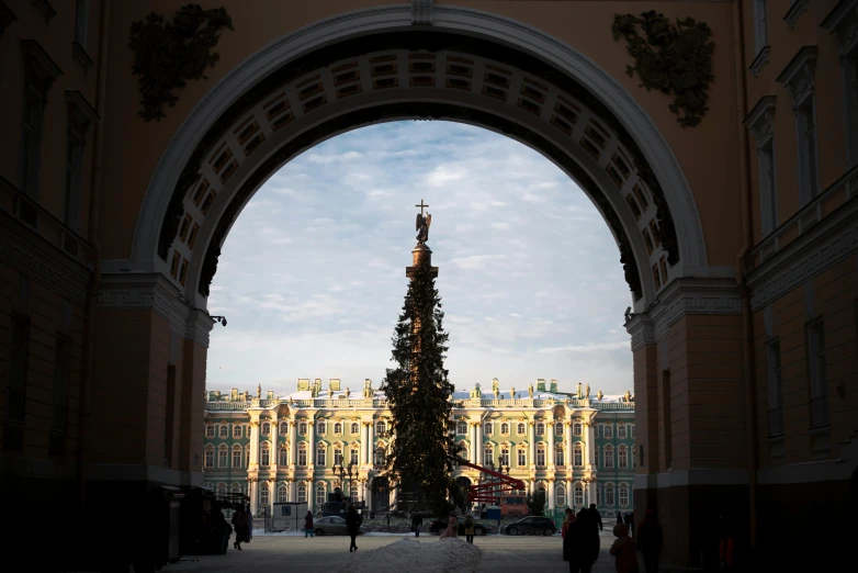 people walking in the street and people standing around a very tall tree