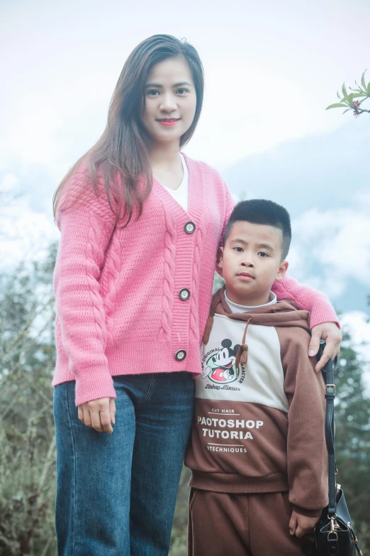 the two boys are standing by the tree