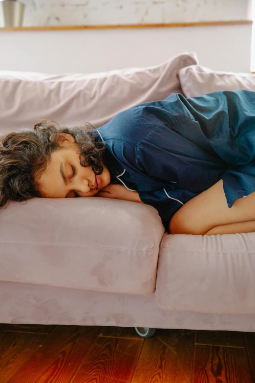 woman laying on couch sleeping listening to headphones