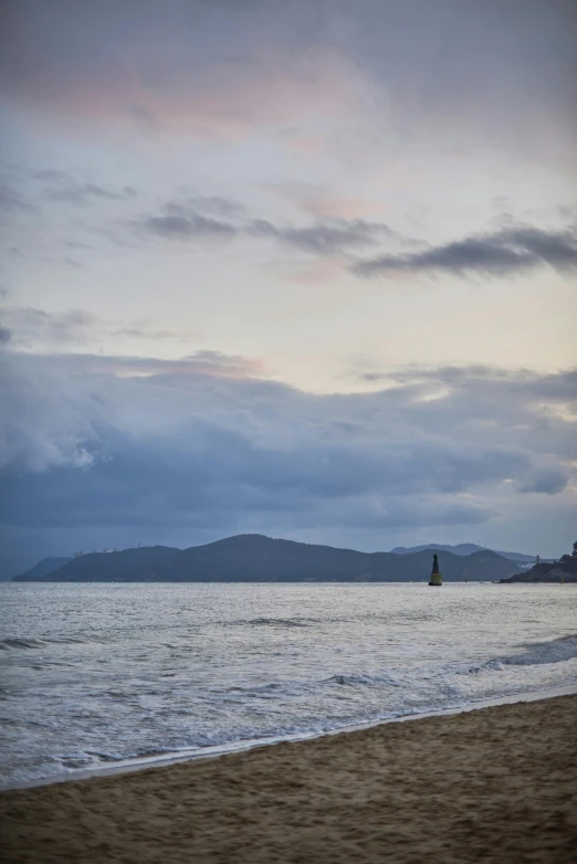 a lone surfer on the beach watching the waves