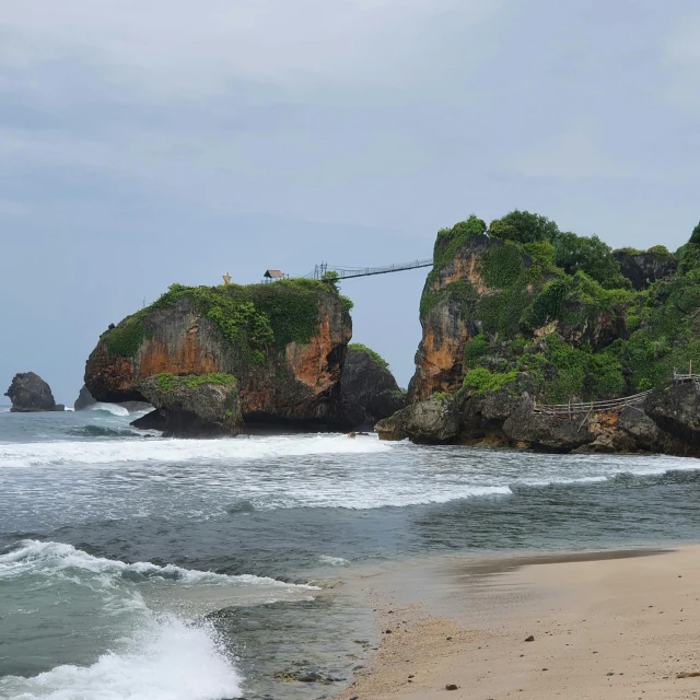 a beach with a rope hanging over it next to the ocean