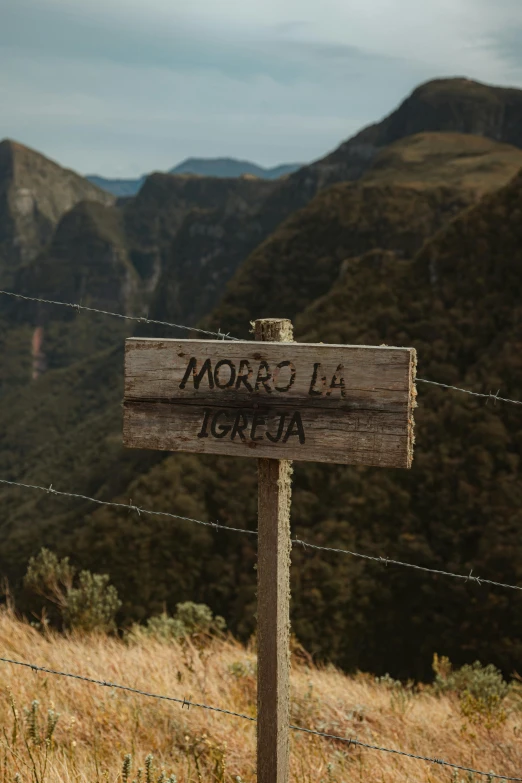 there is a wooden sign on the side of a hill