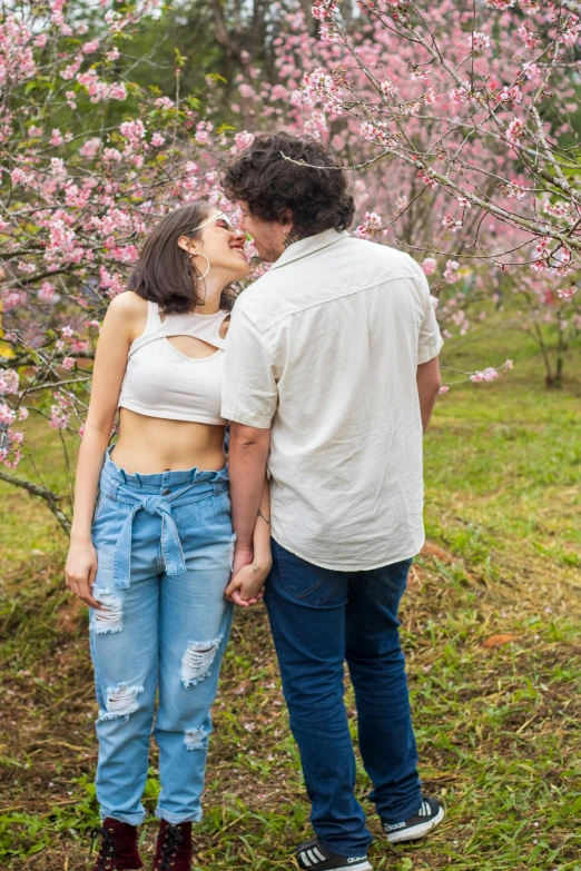 an old man is standing next to a young woman with ripped jeans