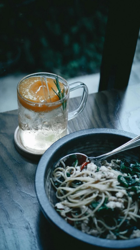 a plate of spaghetti and orange juice on the table