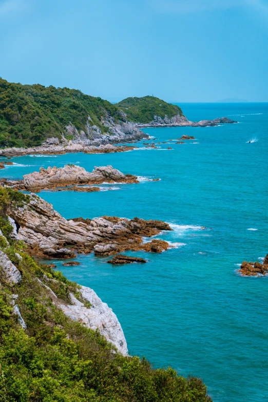 the water is very blue with the rocks and trees on both sides