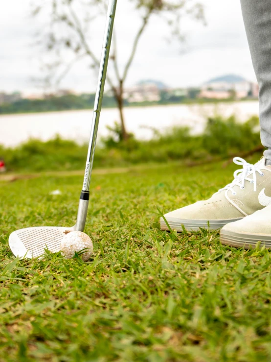 a man who is holding his golf club in the grass