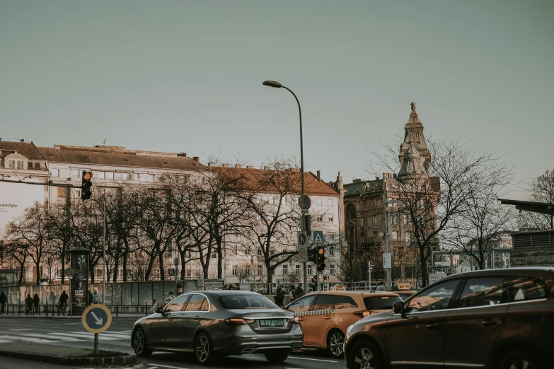 a car drives down a city street lined with tall buildings