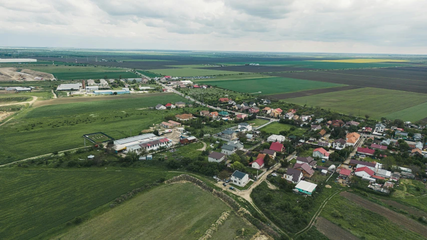 an aerial view of a town with green grass and sky