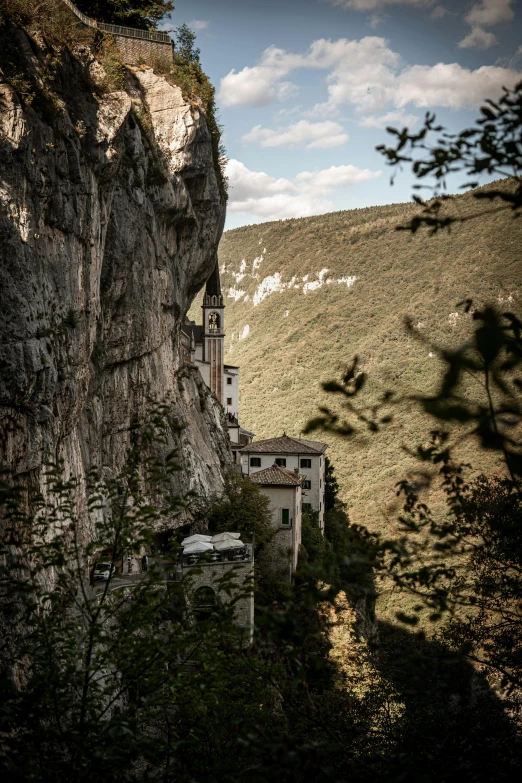 a large cliff with homes and some trees