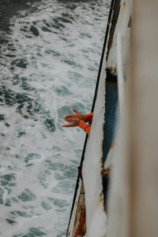 an orange gloved hand reaching into the water