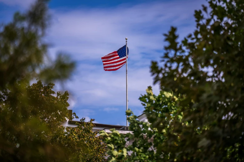 a large american flag waving high in the air