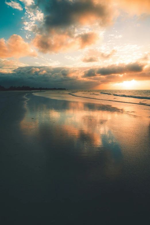 sunset reflected in water on a beach next to the ocean