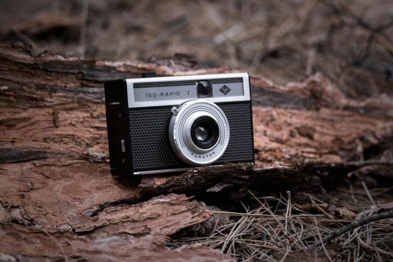 an old camera sitting on some kind of rock