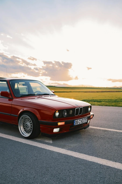 a red bmw is parked on a parking lot