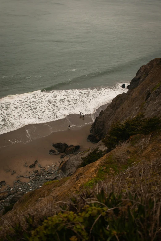 two people who are standing on the shore of the beach