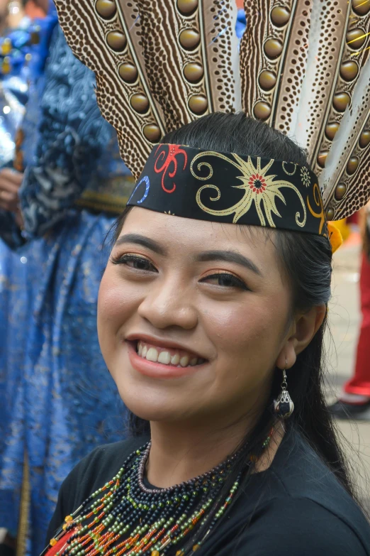 a woman with feathers wearing a hat and beads