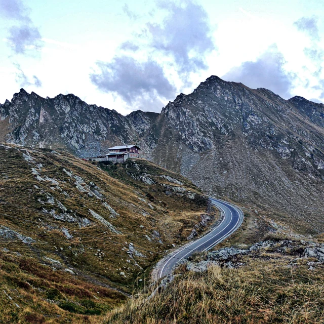 a house is perched on top of the mountain side