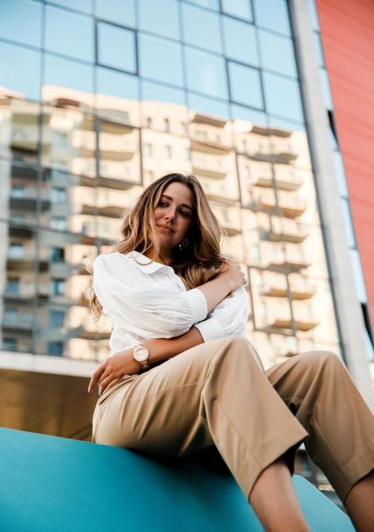 woman sitting on the edge of a tall building