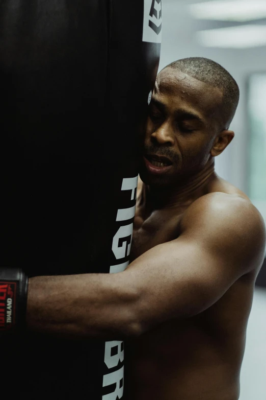 a shirtless man wearing boxing gloves is preparing to hit a punch with his gloves