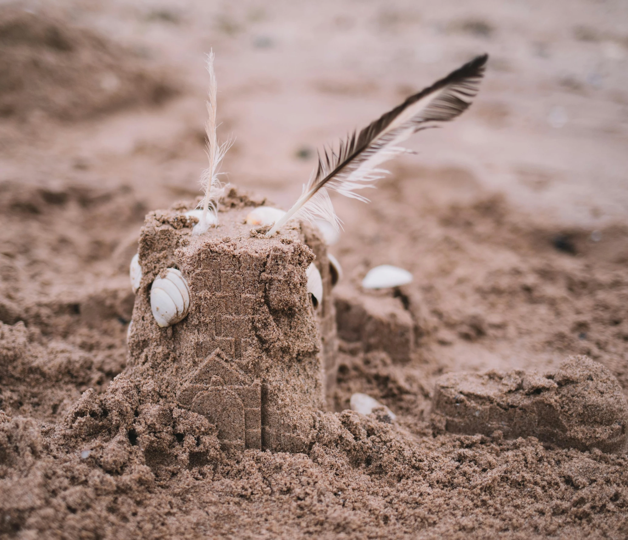 this is a sand box with a feather on top