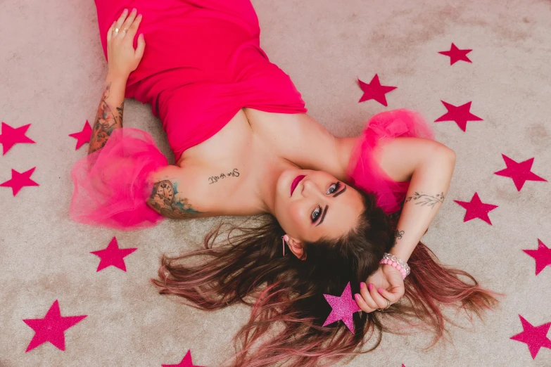 a girl in pink shirt lying on carpet with stars