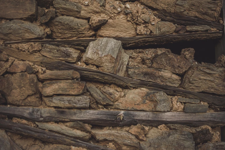 a rustic looking rock wall is displayed in an old stone building