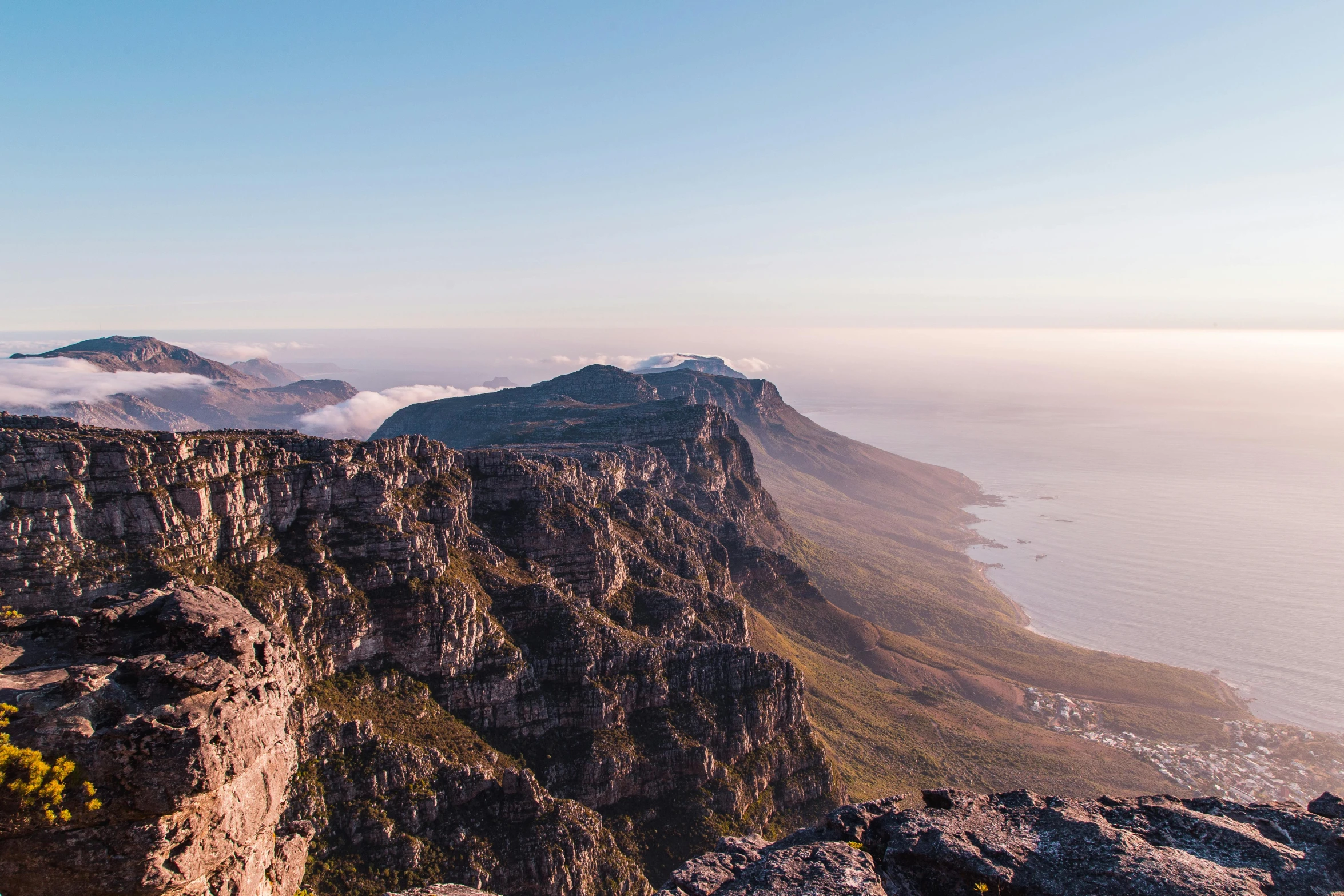 the view of the ocean and the mountains below from the top of the mountain