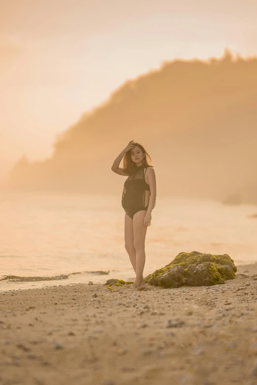 a woman in a bathing suit standing on a beach