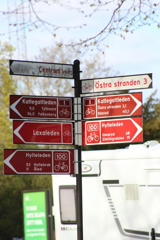 four street signs sitting in front of a white trailer