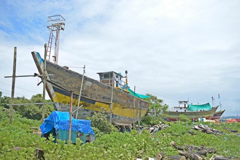 a wooden boat docked next to a building on grass