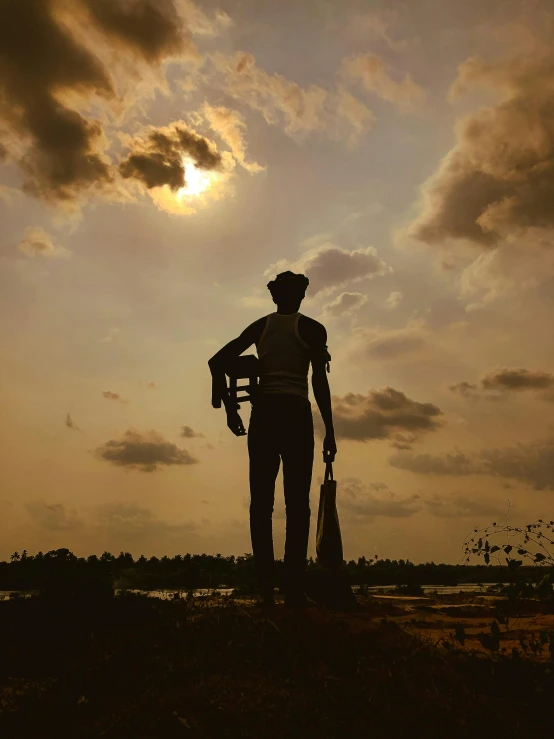 a man standing next to a tree holding two large wooden oars