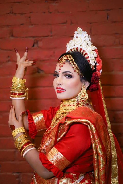 woman dressed in bright dress and holding her hand up