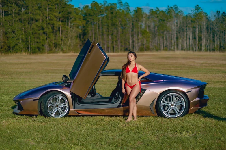 a pretty young lady standing next to a beautiful brown sports car